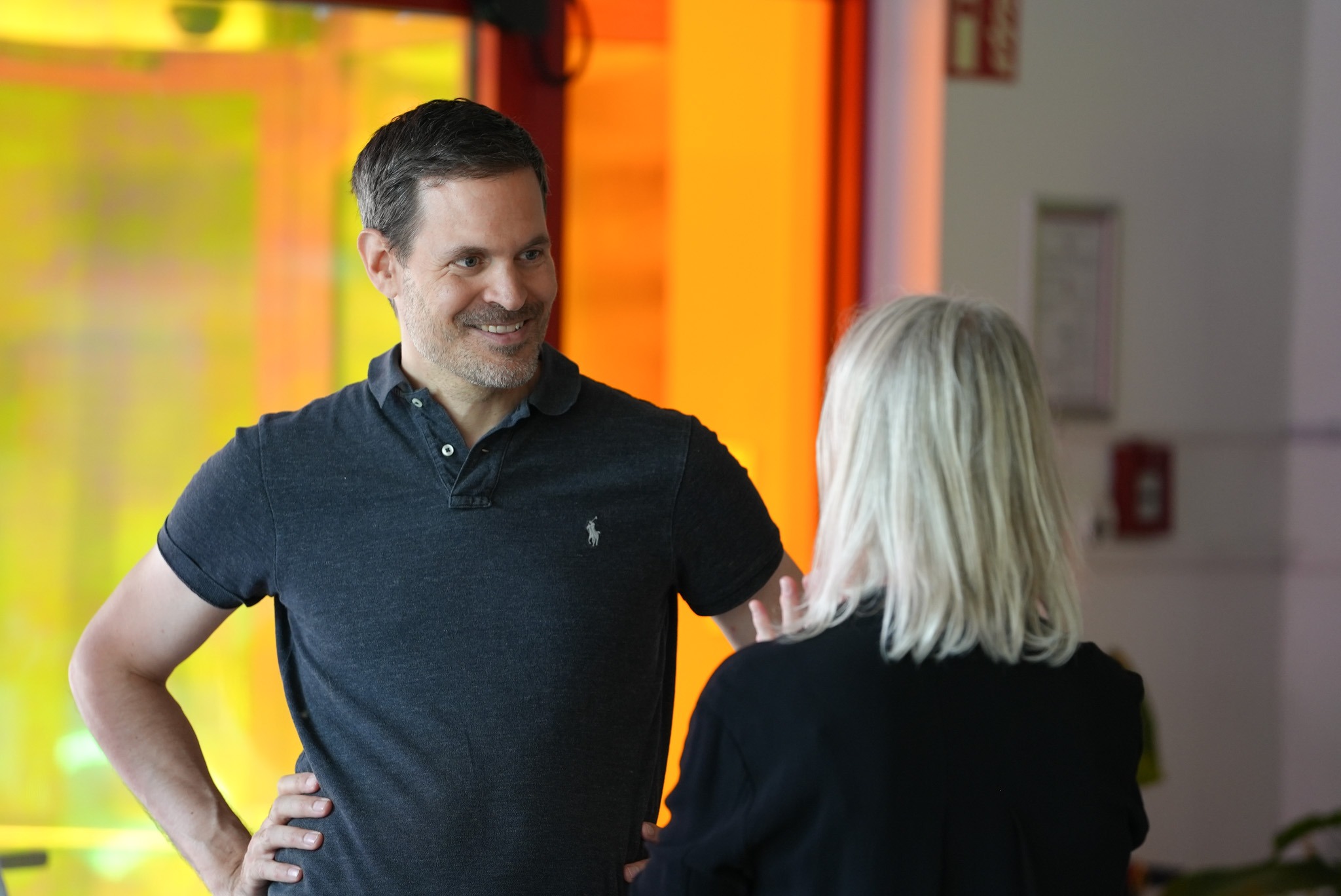 Benjamin Otto lächelnd im Gespräch mit zweiter Person